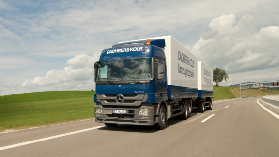 Ein moderner Lkw mit Anhänger des Umzugsunternehmens DACHSER & KOLB auf der Straße für den sicheren Transport beim Auslandsumzug.