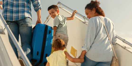Familie mit Kindern steigt ins Flugzeug – Symbolbild für internationalen Umzug