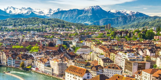 Panorama der Stadt Luzern mit der Jesuitenkirche und den Schweizer Alpen im Hintergrund für den Auslandsumzug in die Schweiz mit DACHSER & KOLB.