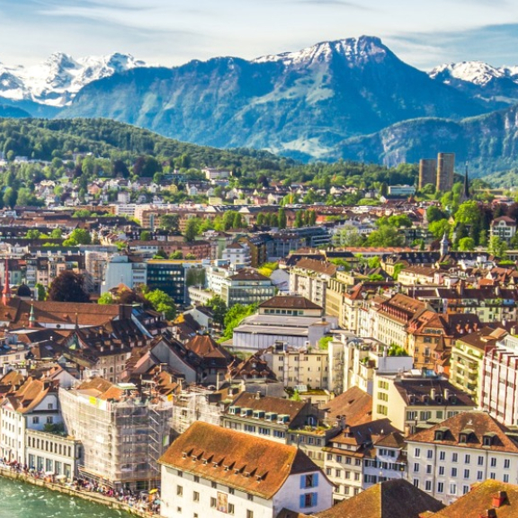 Panorama der Stadt Luzern mit der Jesuitenkirche und den Schweizer Alpen im Hintergrund für den Auslandsumzug in die Schweiz mit DACHSER & KOLB.