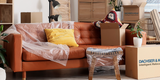 Wohnzimmer mit verpackten Möbeln und Kartons – Symbolbild für professionelle Neumöbellogistik