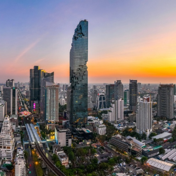 Farbenfrohes Stadtpanorama von Bangkok bei Sonnenuntergang als Zielregion für den sicheren Überseeumzug mit DACHSER & KOLB nach Thailand.