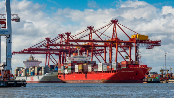 Rote Containerkräne im Hafen von Melbourne bei der Entladung von Seefracht für die Zollabfertigung beim Australien-Umzug mit DACHSER & KOLB.