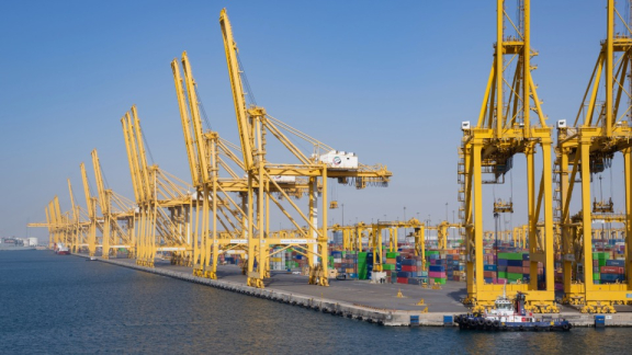 Großer Containerhafen Jebel Ali in den VAE mit gelben Hafenkränen und Containern für den Überseeumzug mit DACHSER & KOLB.