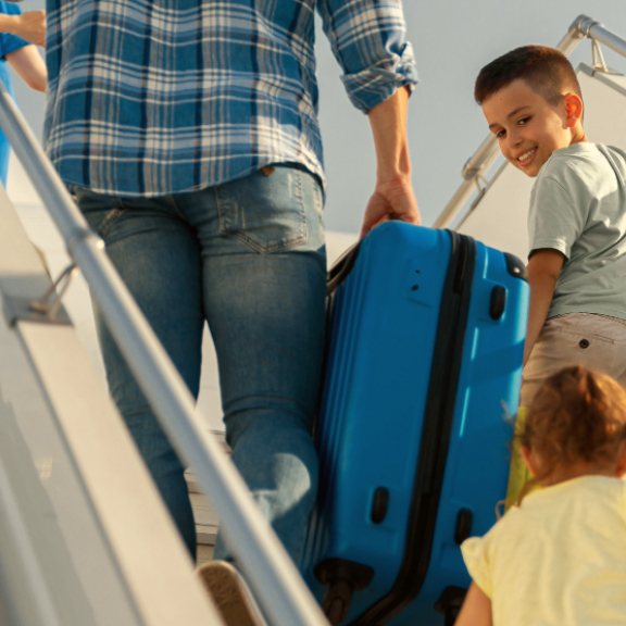 Familie mit Kindern steigt ins Flugzeug – Symbolbild für internationalen Umzug