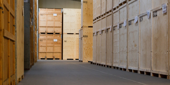 Reihe nummerierter Holzkisten in einem gesicherten Umzugslager zur sicheren Einlagerung von Umzugsgut