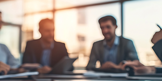 Geschäftliches Treffen der Mitarbeiter bei DACHSER & KOLB in einem modernen Büro mit viel Tageslicht.