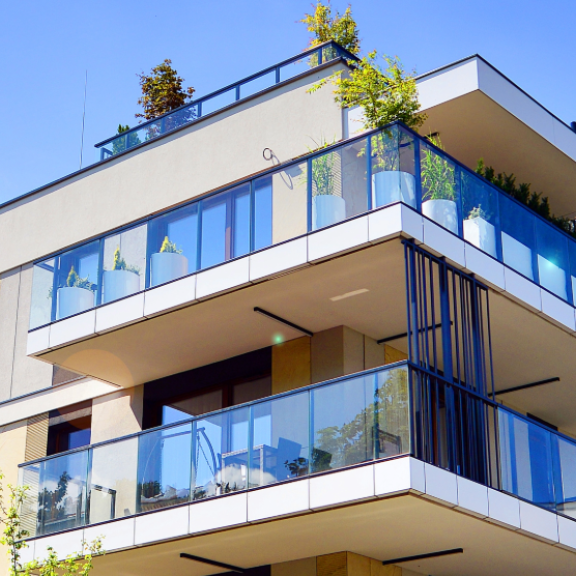 Modernes Mehrfamilienhaus in Deutschland mit Balkonen unter blauem Himmel, relevant für den Mietspiegel.