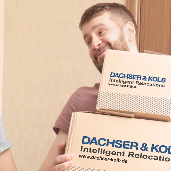 Zwei Männer tragen lachend Umzugskartons – Beispiel dafür, wie man Umzugskartons richtig packen und transportieren kann.