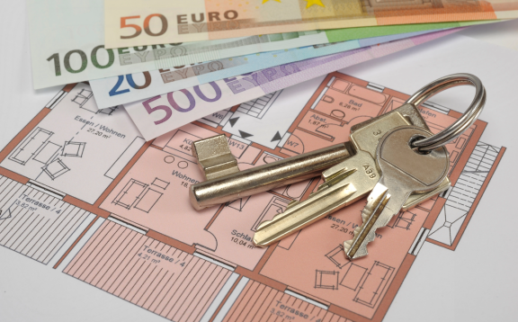 Schlüssel und Geldscheine auf Wohnungsplan – symbolische Darstellung der finanziellen Aspekte einer Wohnungsübergabe