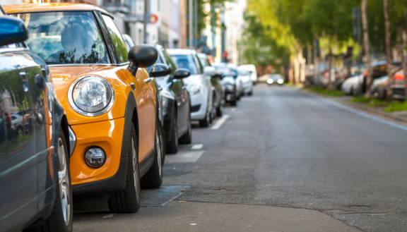 Mehrere Autos parken verbotswidrig am Straßenrand, obwohl Halteverbotsschilder aufgestellt sind.