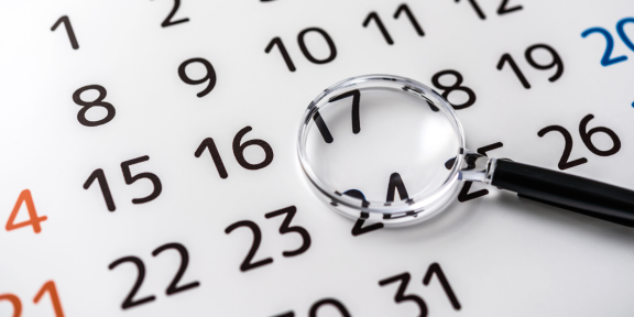 Kalender mit Lupe, Fokus auf Kündigungsfrist bei Wohnungsauflösung, wichtiges Datum bei Wohnung kündigen