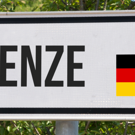 Schild „Grenze“ mit Pfeil sowie deutscher und Schweizer Flagge als Symbol für Zoll Schweiz
