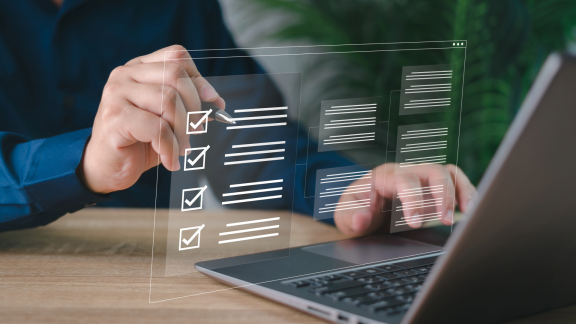 Person nutzt am Laptop eine digitale Checkliste mit Häkchen als Symbol für Zoll Schweiz