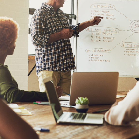Team bei einer Besprechung mit Whiteboard – Symbolbild für Tipps und Wissen im Umzugs-ABC