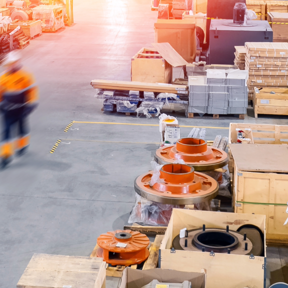 Weitläufiges Lager mit vielen Holzkisten (Crates) und einem Arbeiter in Bewegung. Industrielle Lagerhaltung und Logistik.
