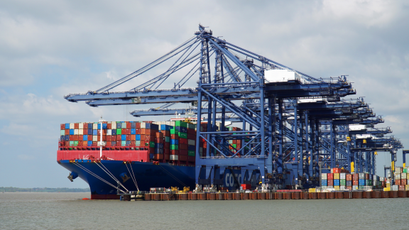 Containerschiff wird im Hafen be- und entladen, effiziente Logistik und ETD-Koordination am Terminal.