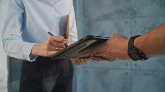 Zusteller lässt Empfänger auf einem Lieferschein unterschreiben – Proof of Delivery (POD) für eine nachvollziehbare Zustellung