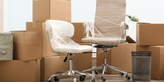 Eingepackte Bürostühle und strukturierte Umzugskartons für die professionelle Umzugslogistik und den Firmenumzug mit DACHSER & KOLB.