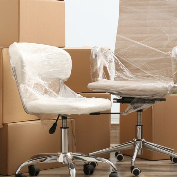 Eingepackte Bürostühle und strukturierte Umzugskartons für die professionelle Umzugslogistik und den Firmenumzug mit DACHSER & KOLB.
