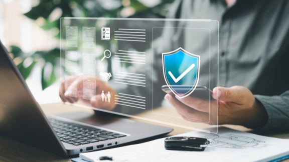 Ein Mitarbeiter prüft digitalen Versicherungsschutz und Risikomanagement am Laptop.