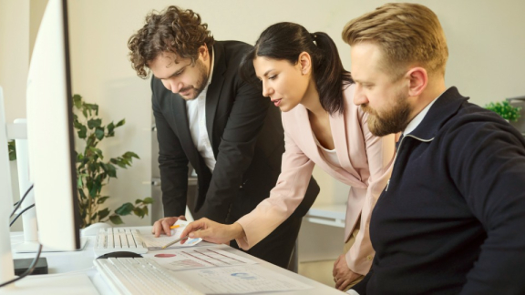 Ein Projektteam analysiert gemeinsam Daten am Monitor im Büro – Für eine effiziente Zusammenarbeit, abgestimmte Abläufe und professionelle Steuerung im Procurement.