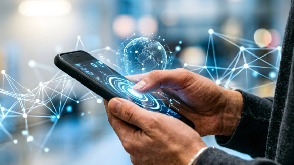 Ein leuchtender digitaler Globus mit Daten-Netzwerk über einem Smartphone zur Veranschaulichung der weltweiten Reichweite für Global Mobility Services von DACHSER & KOLB.